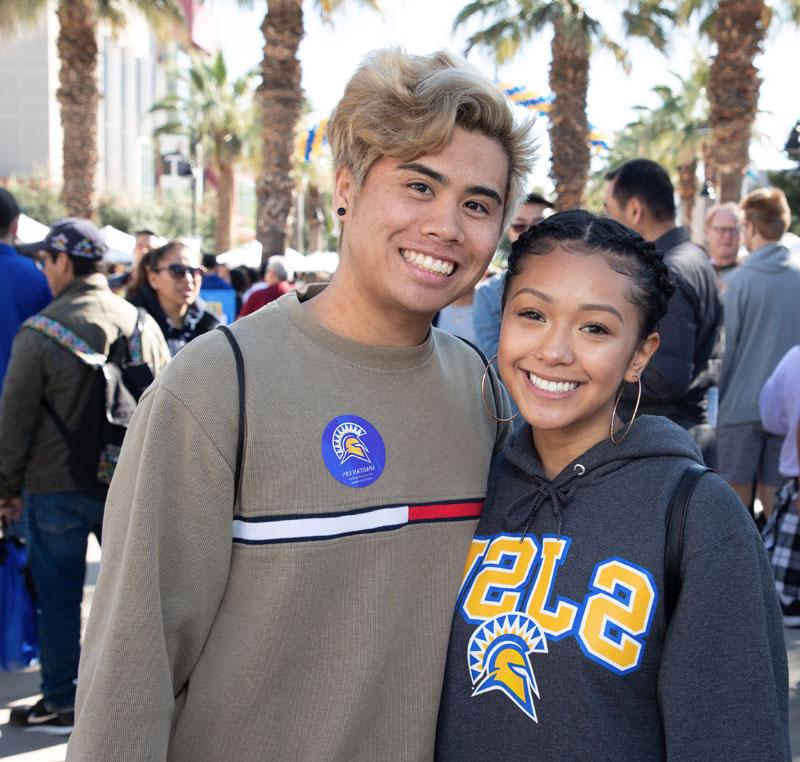 Two smiling students, a female and male, posing together.